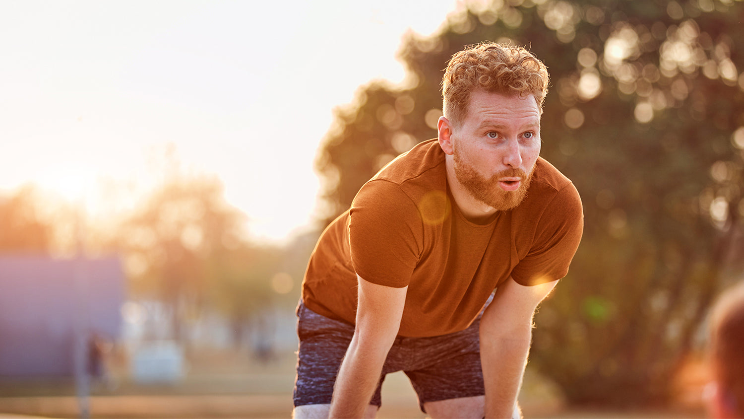 Man taking a break during a run outdoors - Kaizen Naturals